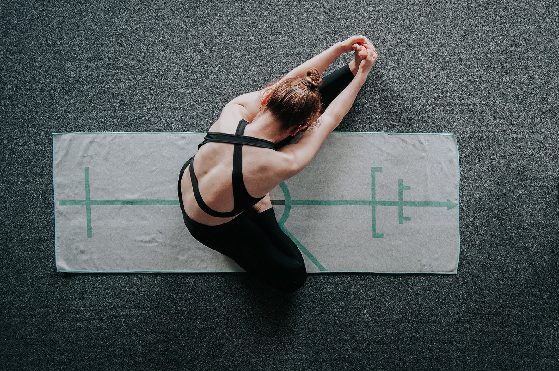 bikram hot Yoga student doing head to knee with stretching pose or janushirasana with paschimotthanasana on the best bikram hot yoga mat towel